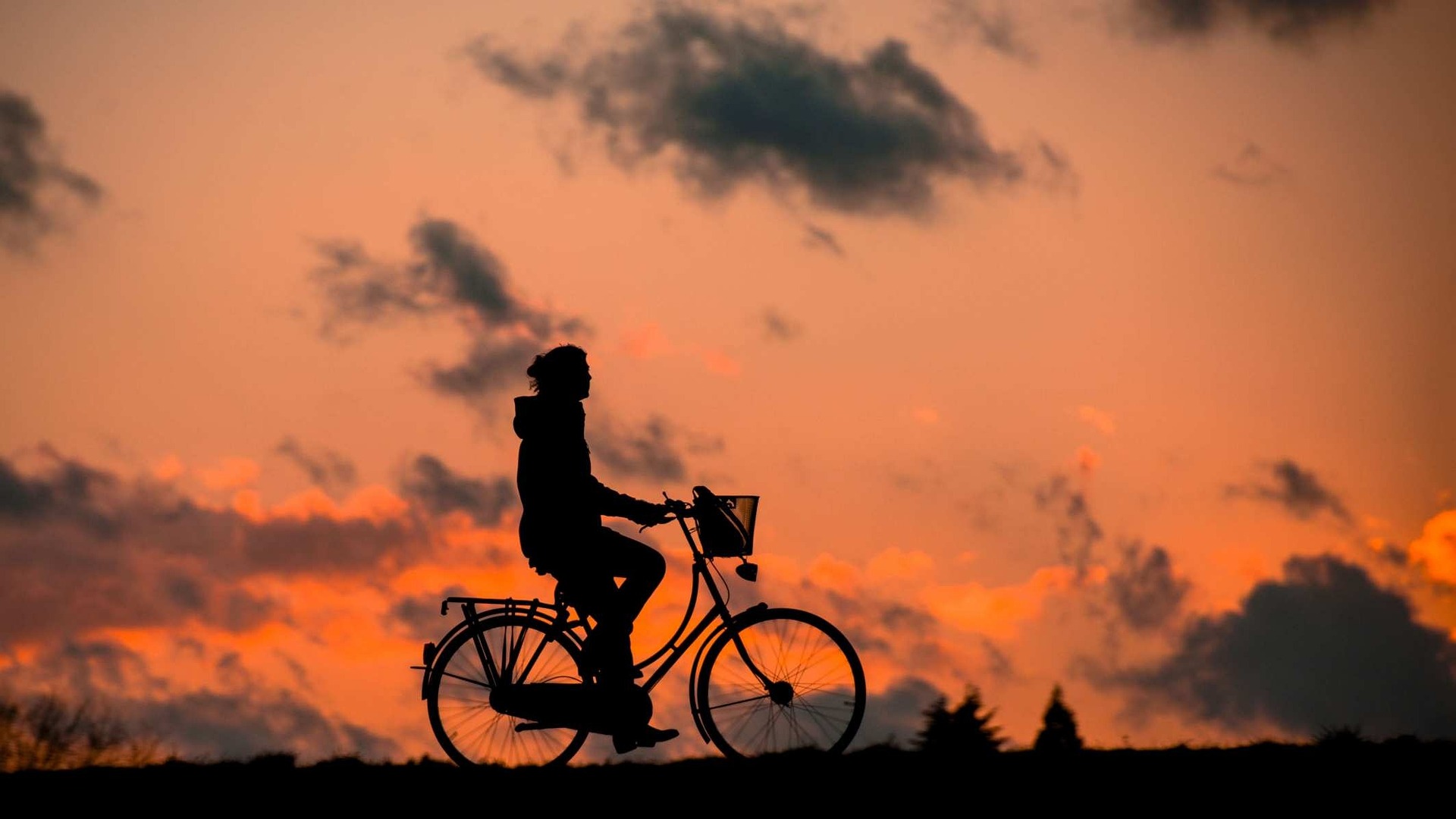 Un cycliste profite d'un moment de repos au coucher du soleil.